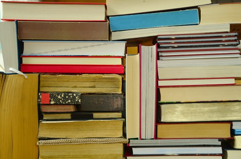 A photo showing a stack of books, reports, research publications, guidelines, and handbooks