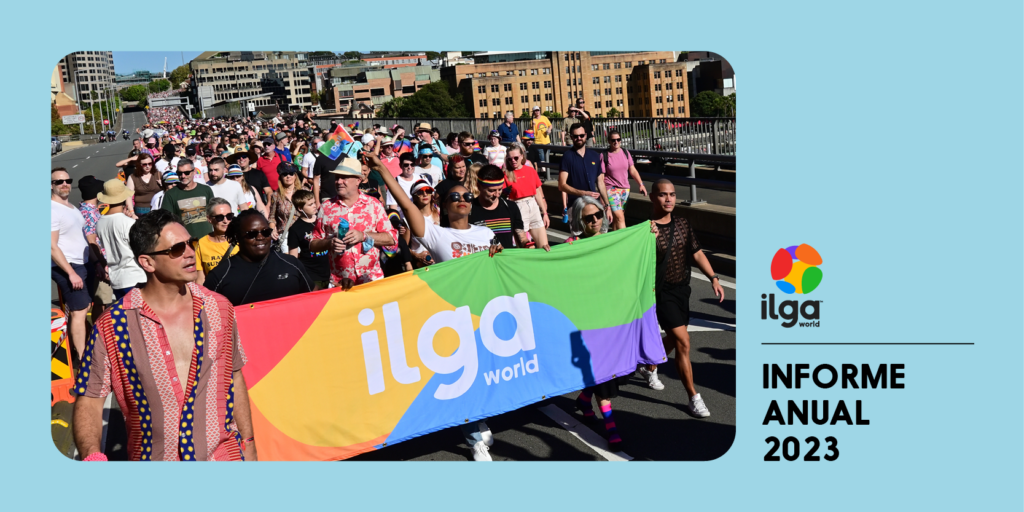 La foto muestra a un grupo de personas marchando detrás de una pancarta de ILGA Mundo con los colores de la bandera del Orgullo, durante el WorldPride 2023 de Sydney. El texto dice "Informe anual de ILGA Mundo 2023".