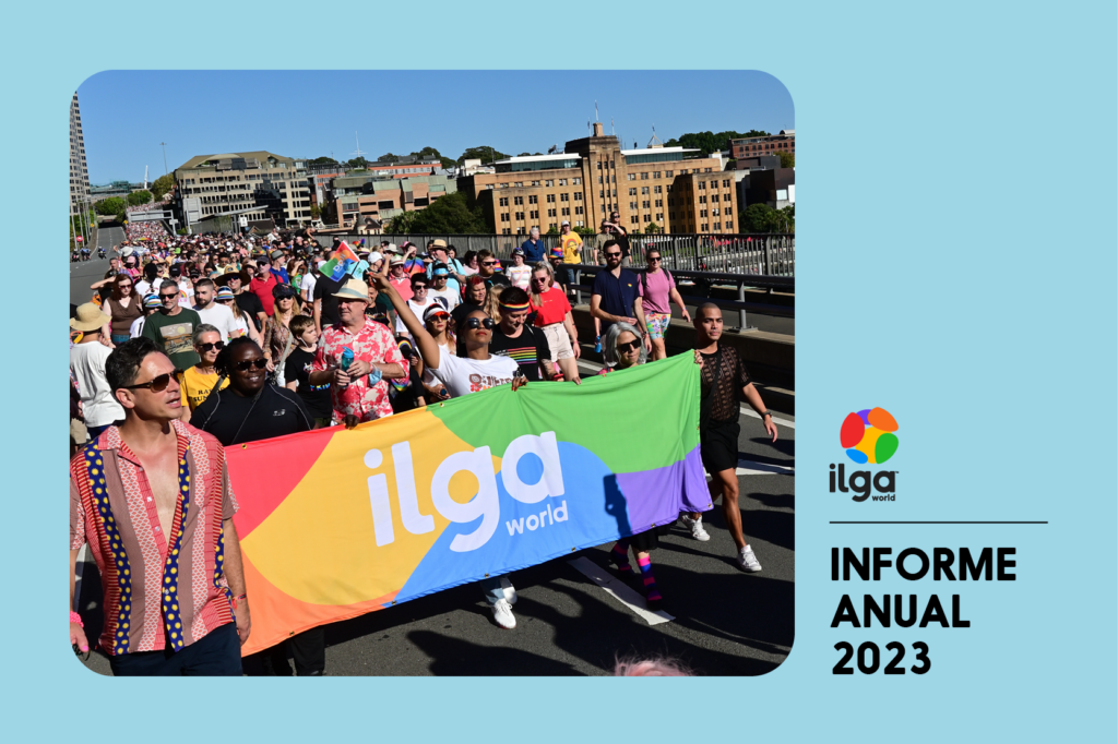 La foto muestra a un grupo de personas marchando detrás de una pancarta de ILGA Mundo con los colores de la bandera del Orgullo, durante el WorldPride 2023 de Sydney. El texto dice "Informe anual de ILGA Mundo 2023".