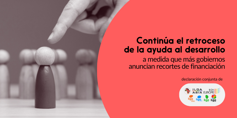 La foto muestra una mano que señala con el dedo a un peón, que es de un color diferente al de los demás peones que lo rodean. El texto dice: «Continúa el retroceso de la ayuda al desarrollo a medida que más gobiernos anuncian recortes de financiación». Los logotipos de ILGA Mundo, Pan Africa ILGA, ILGA Asia, ILGA-Europe, ILGA-NAC, ILGA Oceania e ILGALAC se encuentran en la parte inferior derecha de la imagen.