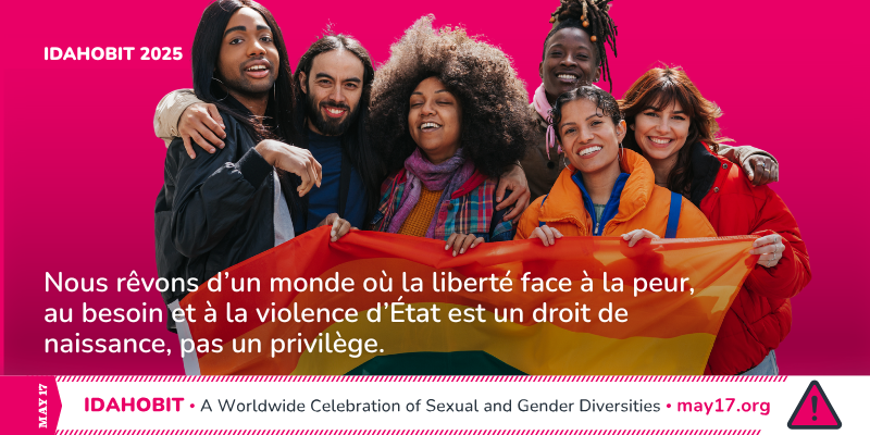 Un groupe de personnes diverses brandit un drapeau arc-en-ciel et sourit à la caméra. Le texte indique : « IDAHOBIT 2025. Nous envisageons un monde où la liberté de vivre sans peur, sans privation et sans violence étatique est un droit inaliénable, et non un privilège. » Une barre en bas au centre affiche le logo May17 avec le slogan : « Une célébration de la diversité sexuelle et de genre ».