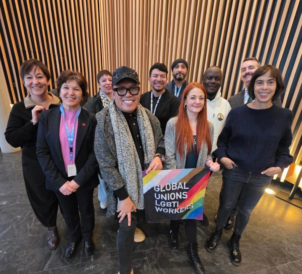 Organisers and panellists of the side event pose with a banner of the Global Unions LGBTI workers in front of the reception of building H l at the Palais de Nations in Geneva, Switzerland.