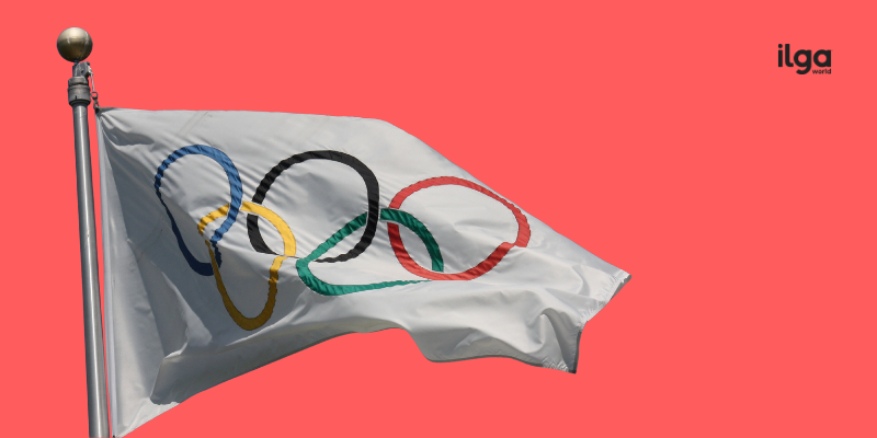 The Olympic flag. The ILGA World logo sits at the top right of the image